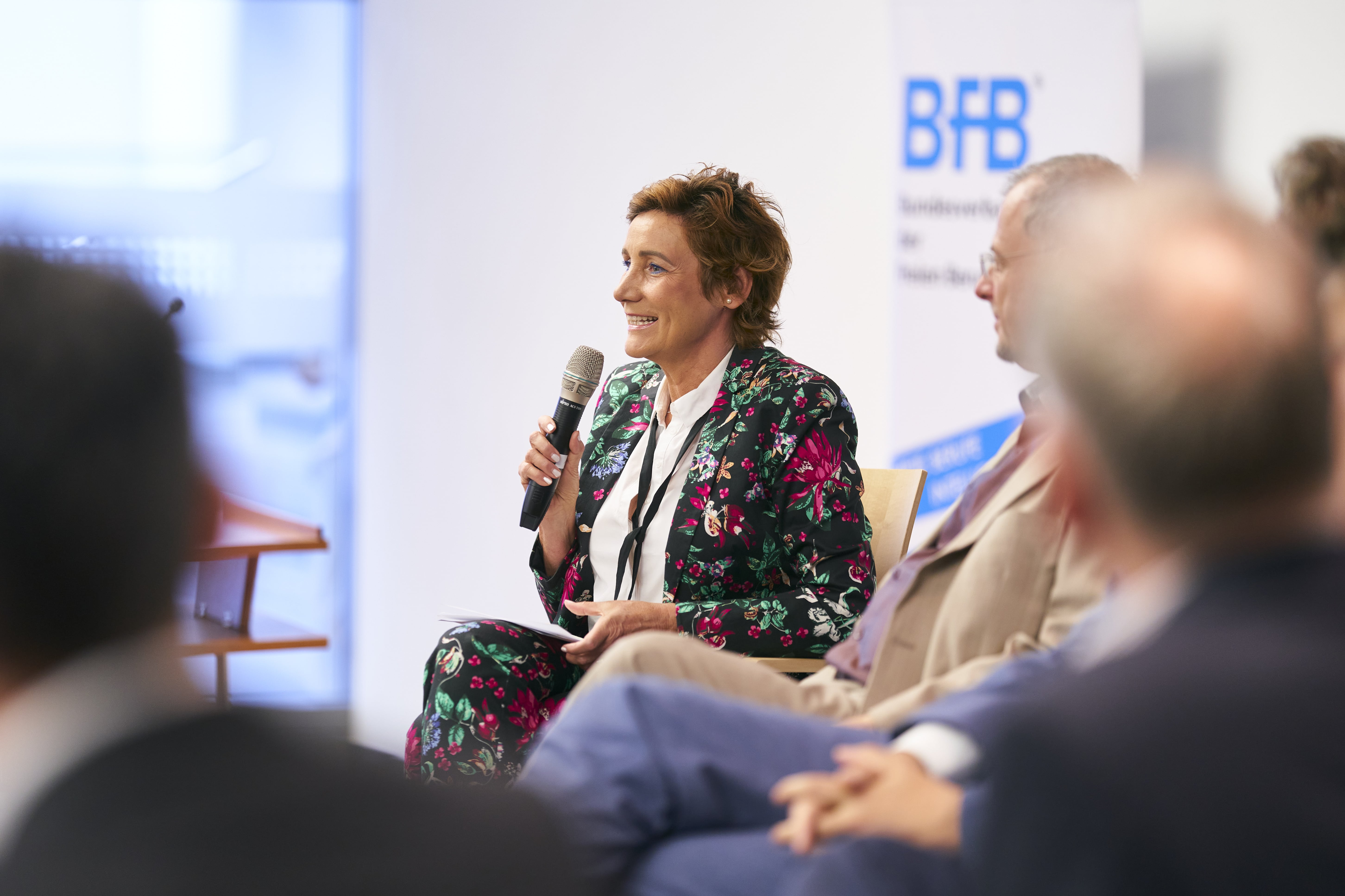 Angela Elis moderiert eine Podiumsdiskussion bei einer Preisverleihung